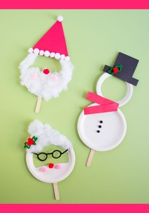 Three masks made of white paper plates including a Santa, Mrs. Claus and a snowperson with a black top hat